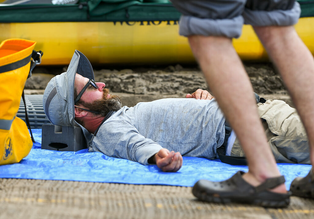 Scott Miller lies on the ground to take a short nap